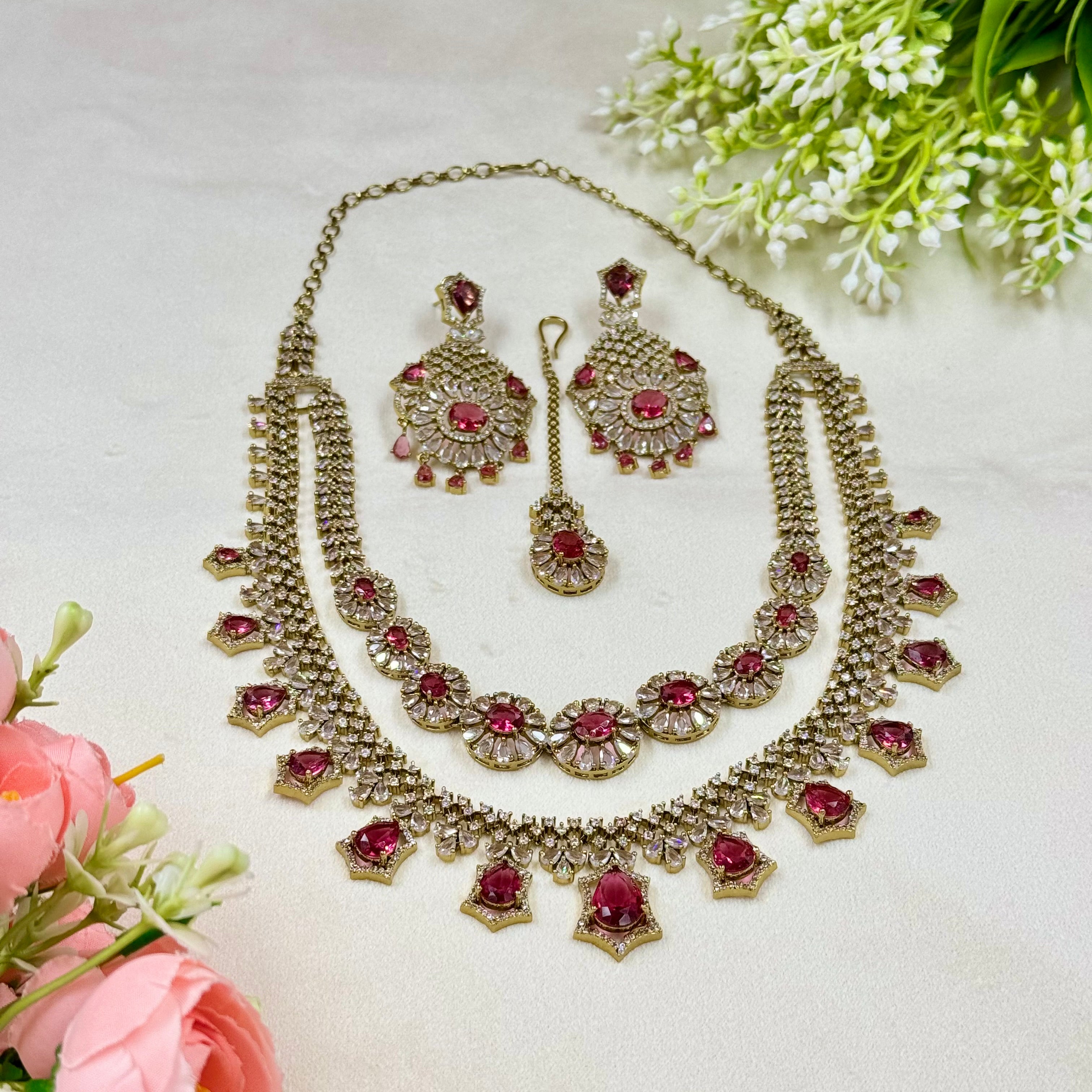 Jewelry set with necklace and earrings on a light background with flowers