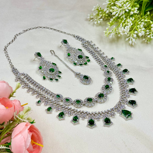 Jewelry set with necklace, earrings, and ring on a light background with flowers.