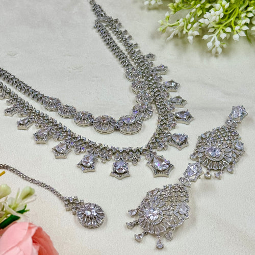 Silver necklace with intricate designs on a light background