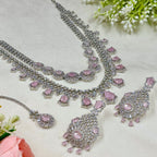 Silver and pink jewelry set on a light background with flowers.