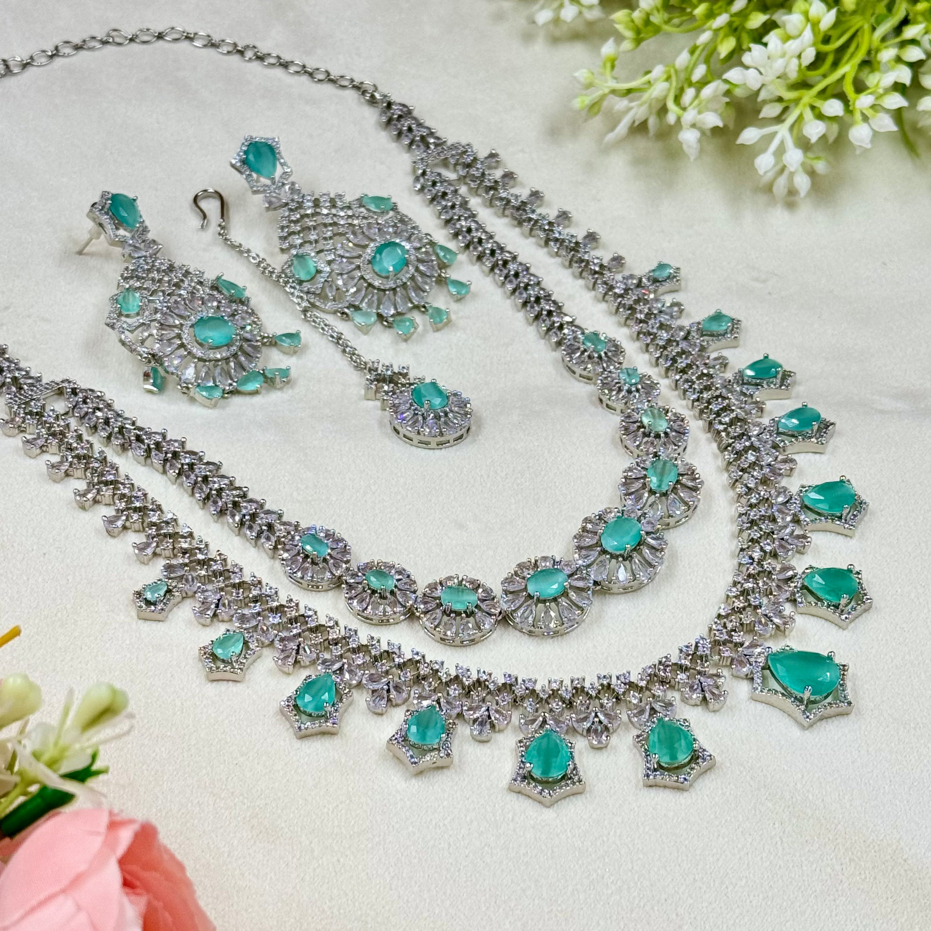 Jewelry set with turquoise stones and silver accents on a light background