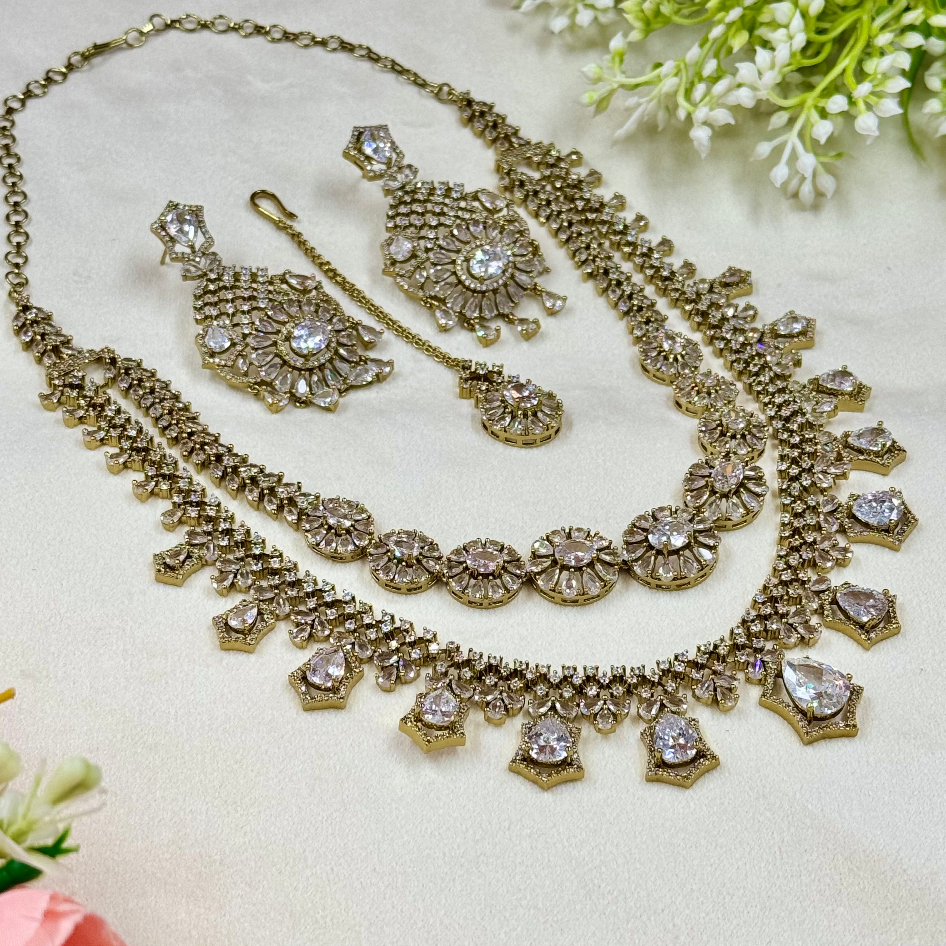 Gold necklace set with crystals on a light background