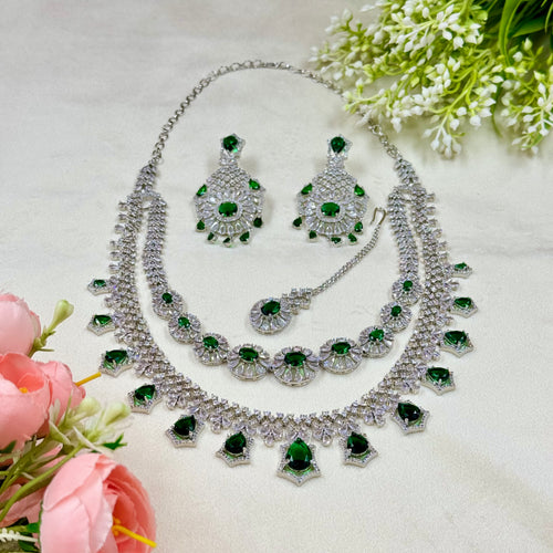 Jewelry set with necklace and earrings on a light background with flowers.