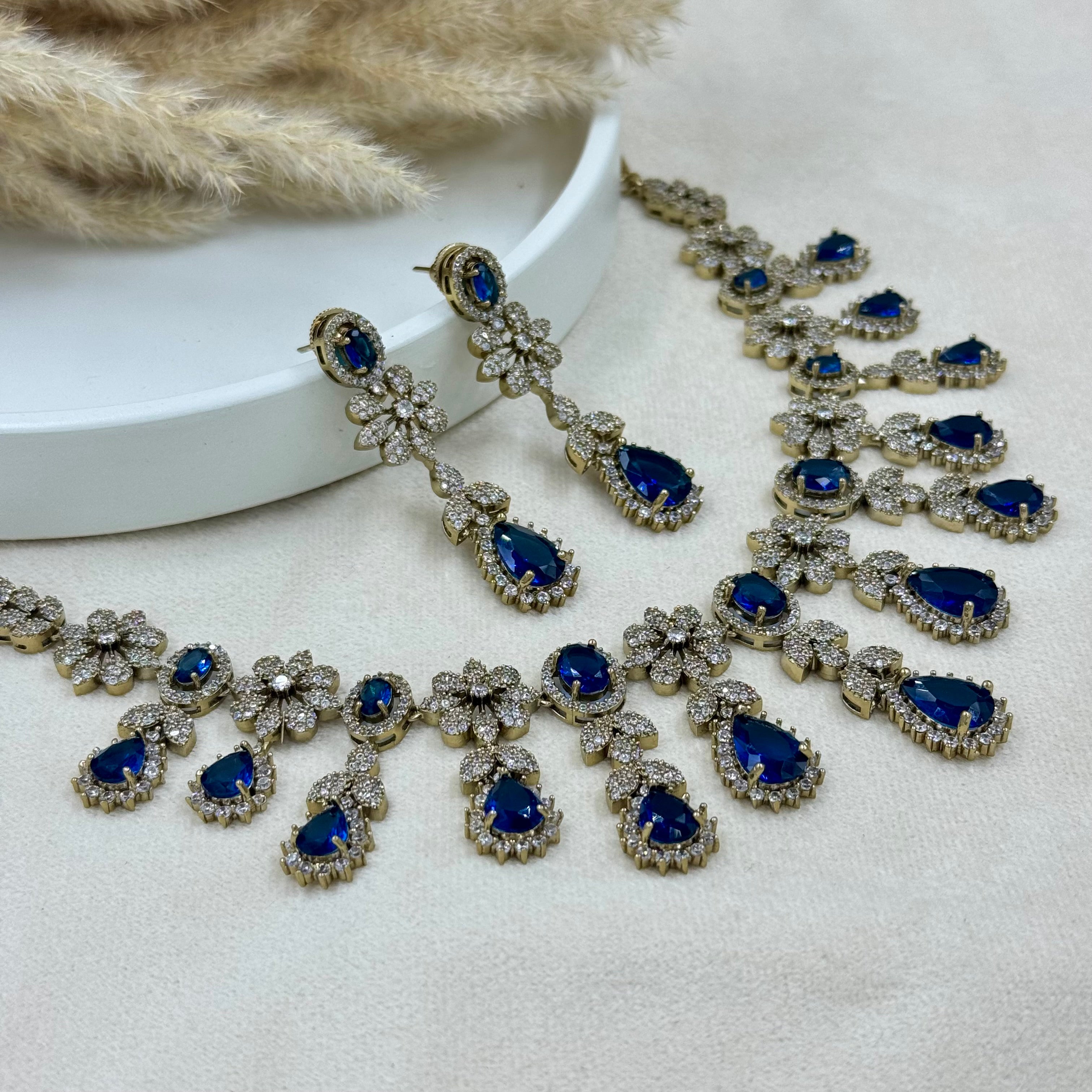 Jewelry set with blue gemstones on a light background