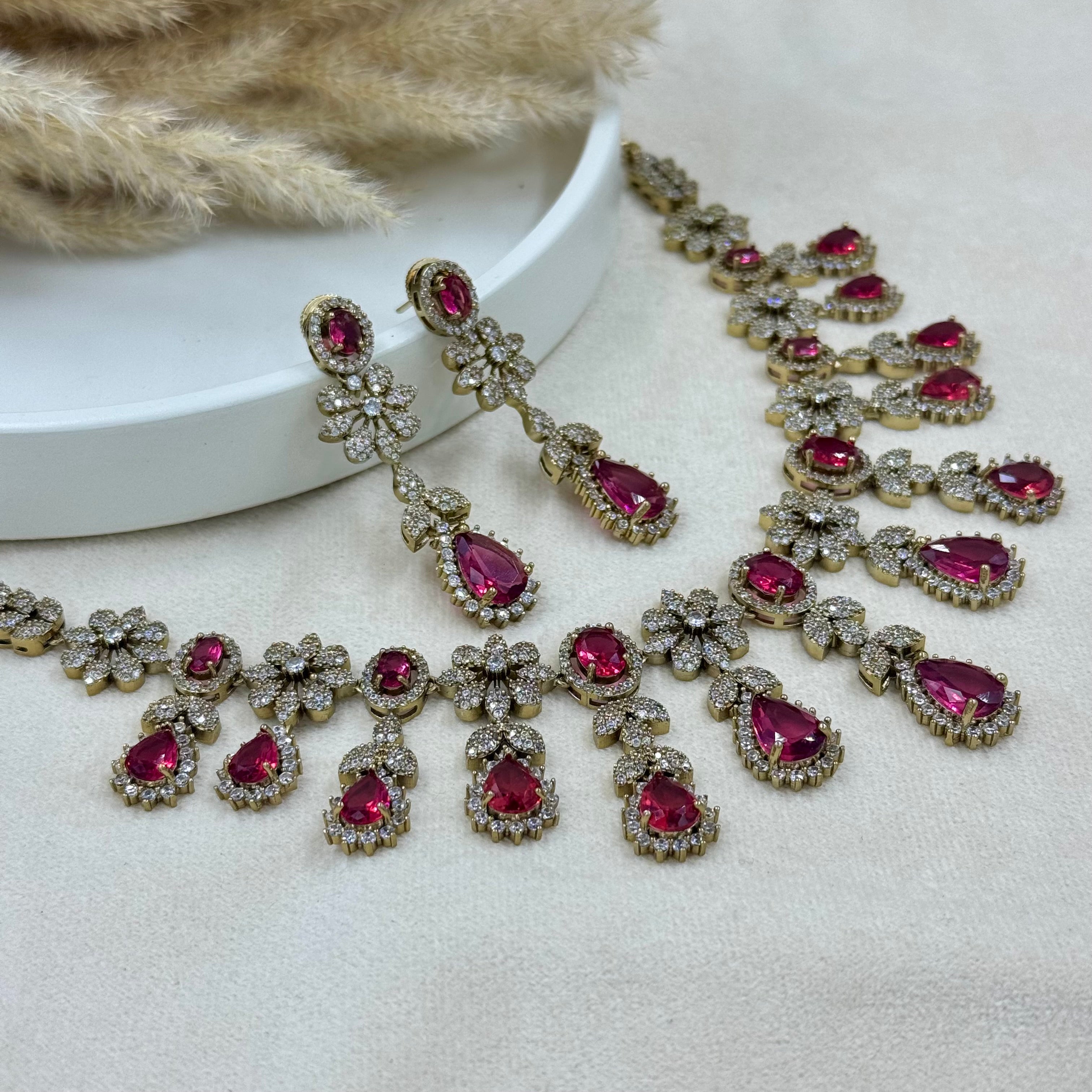 Jewelry set with pink gemstones on a neutral background