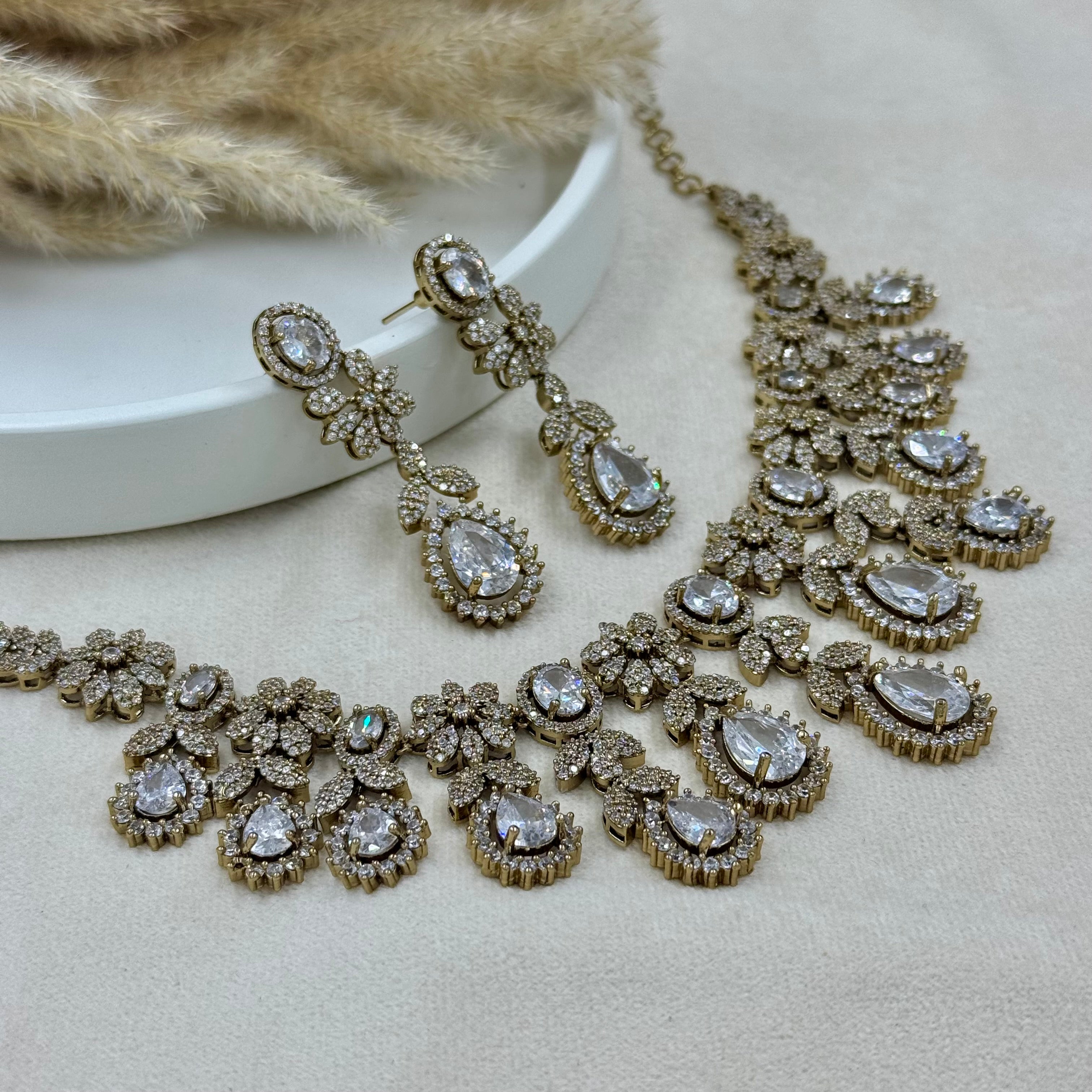 Jewelry set with necklace and earrings on a neutral background