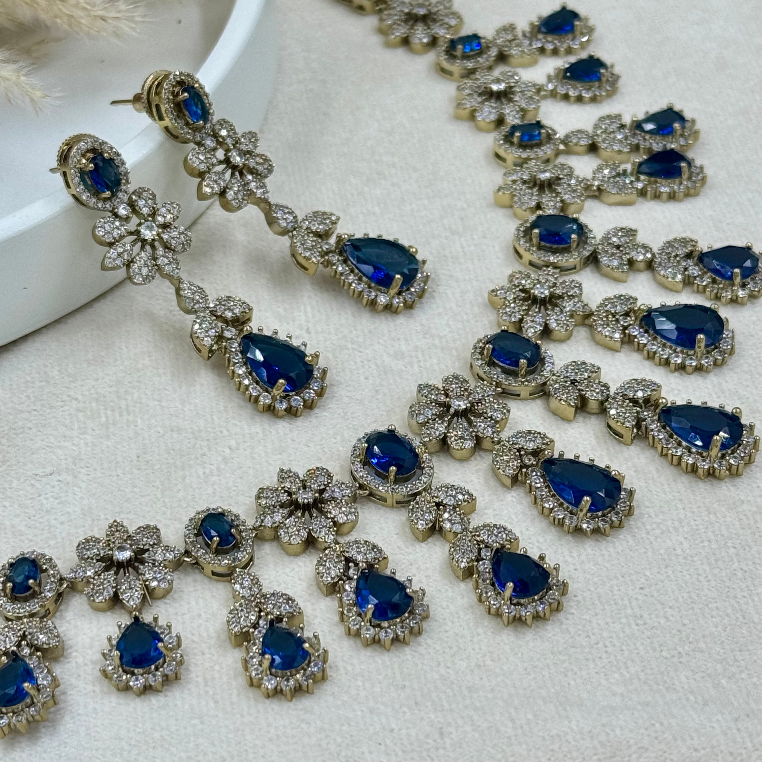 Jewelry set with blue gemstones and silver accents on a light background