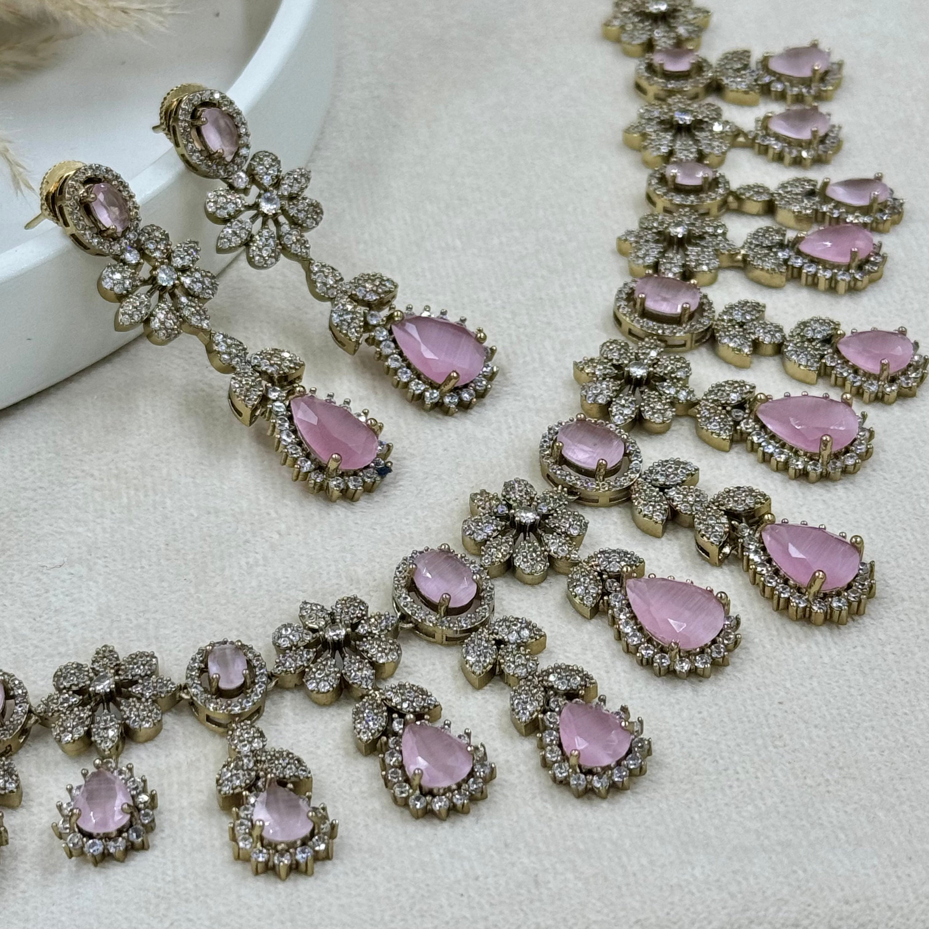 Jewelry set with pink gemstones on a light background