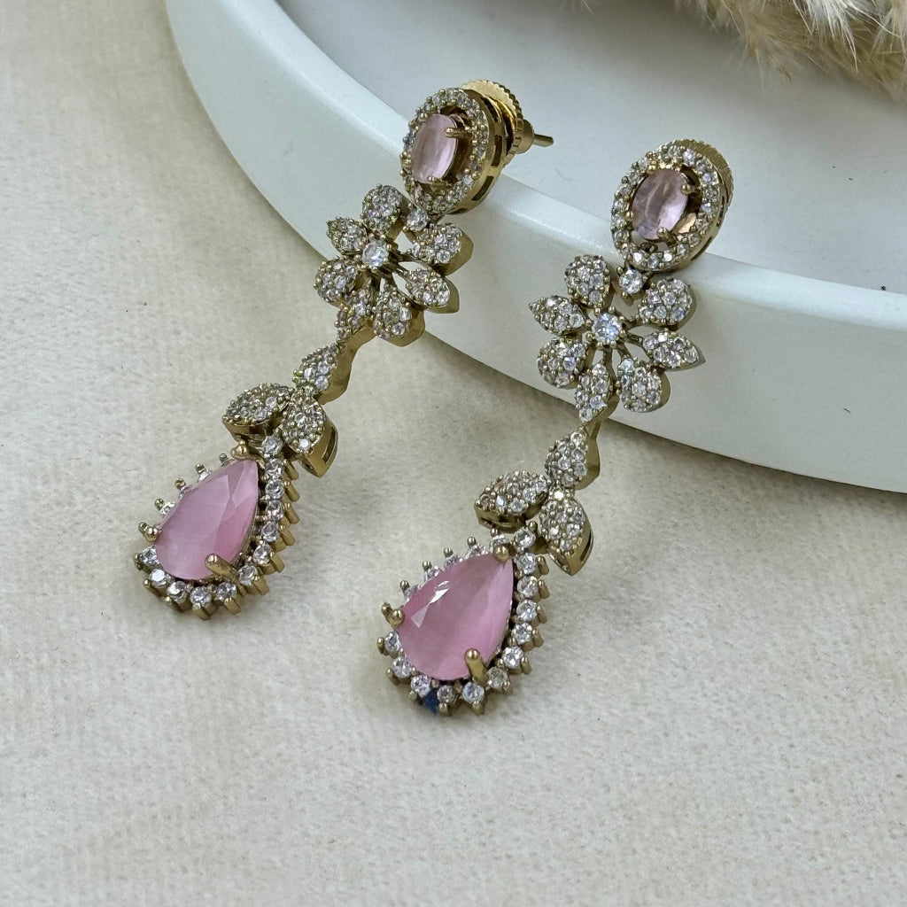Pair of earrings with pink gemstones on a light background