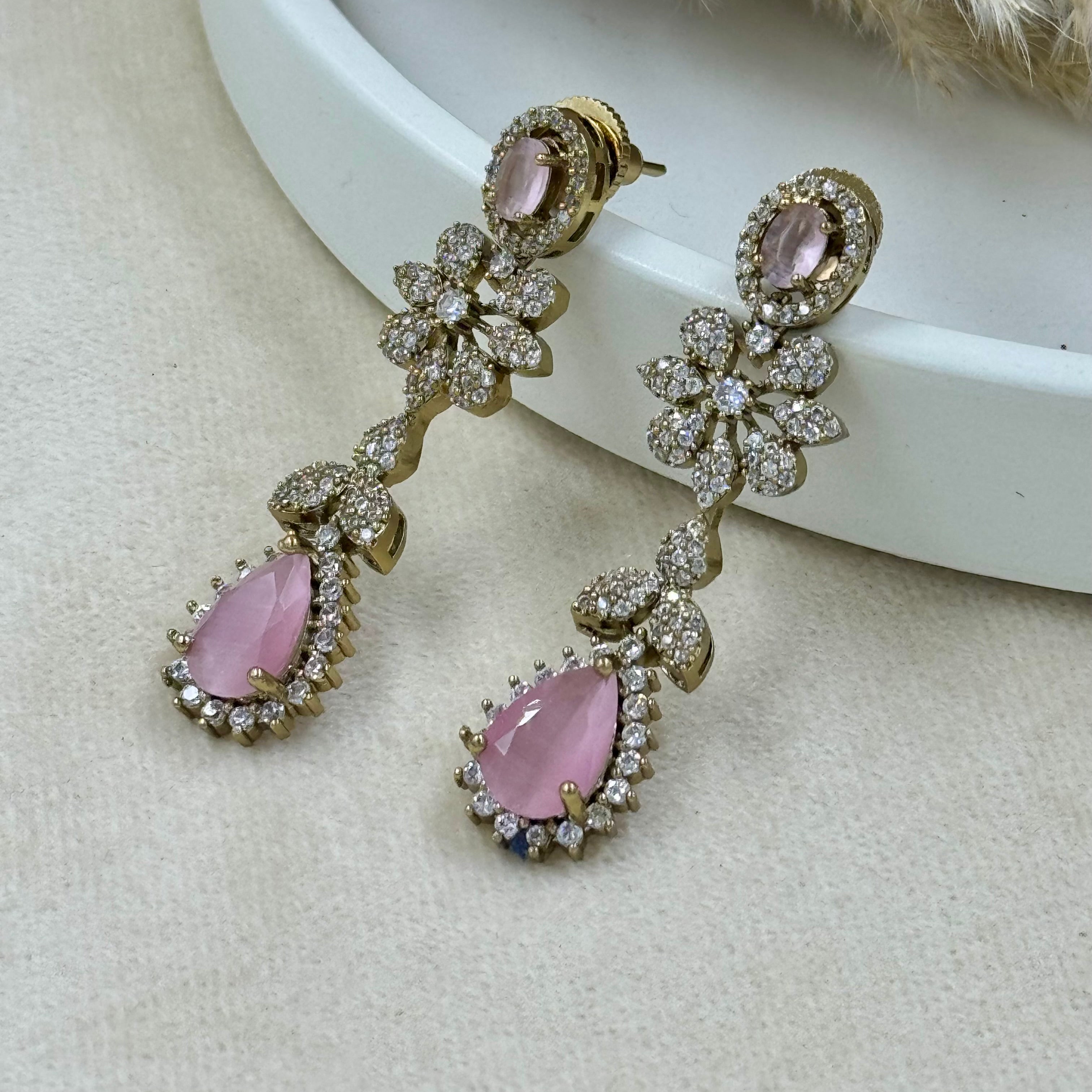 Pair of earrings with pink gemstones on a light background