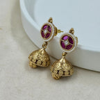 Gold earrings with purple gemstones on a white background